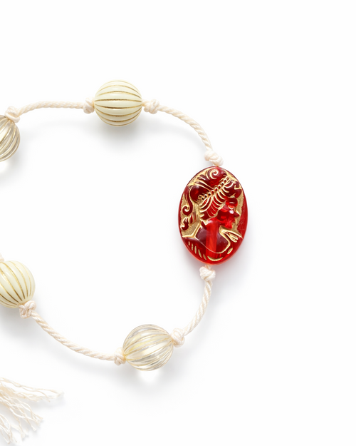 Anther House Bracelet with a red and gold bead on a white background