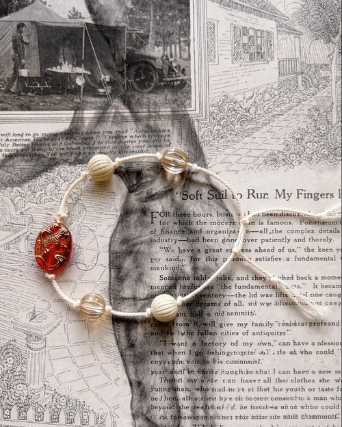 Anther House Bracelet with a red stone on a vintage newspaper background Handmade in Philadelphia