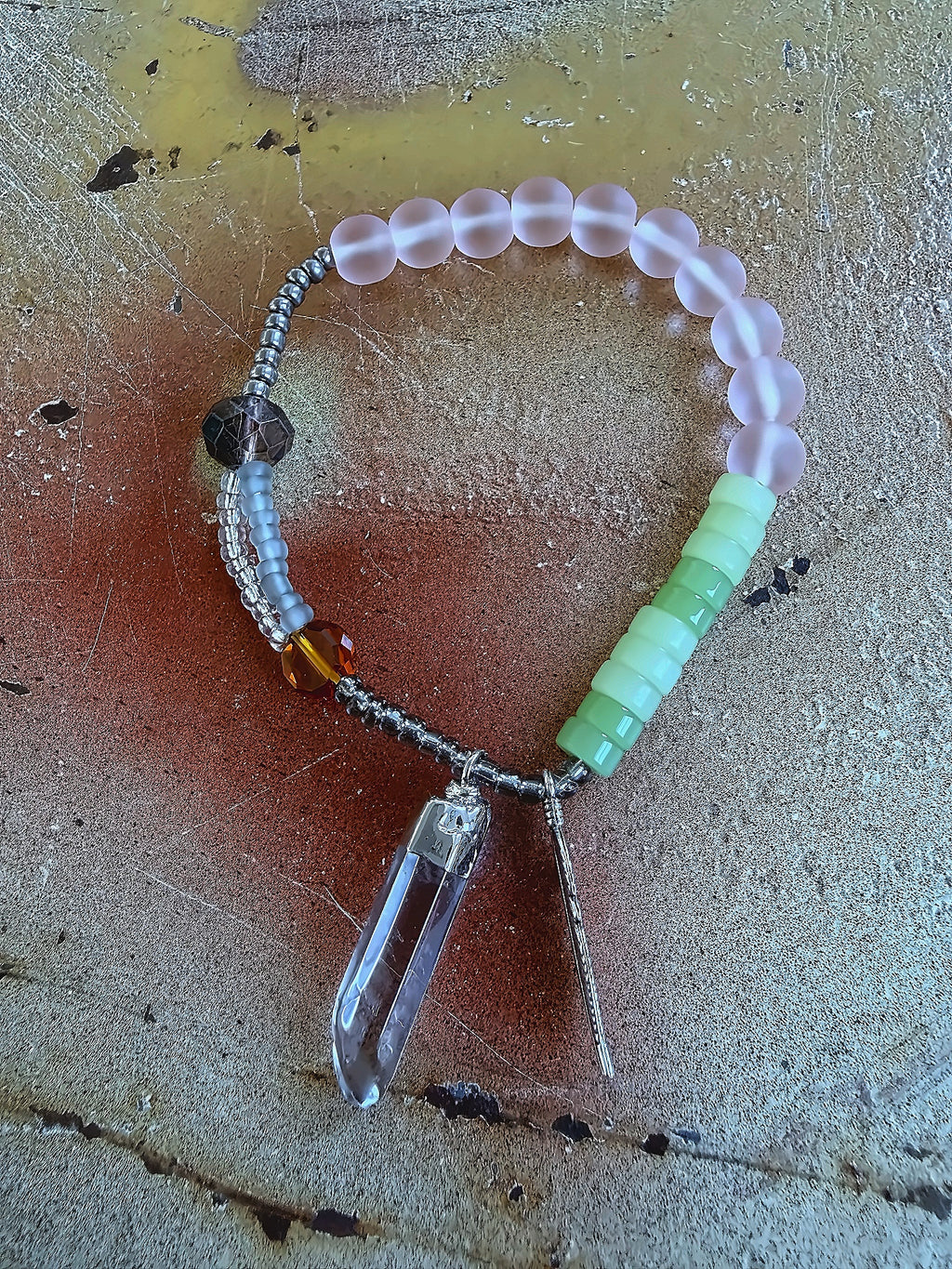 Anther House Beaded bracelet with a Natural crystal pendant on a textured surface Handmade in Philly