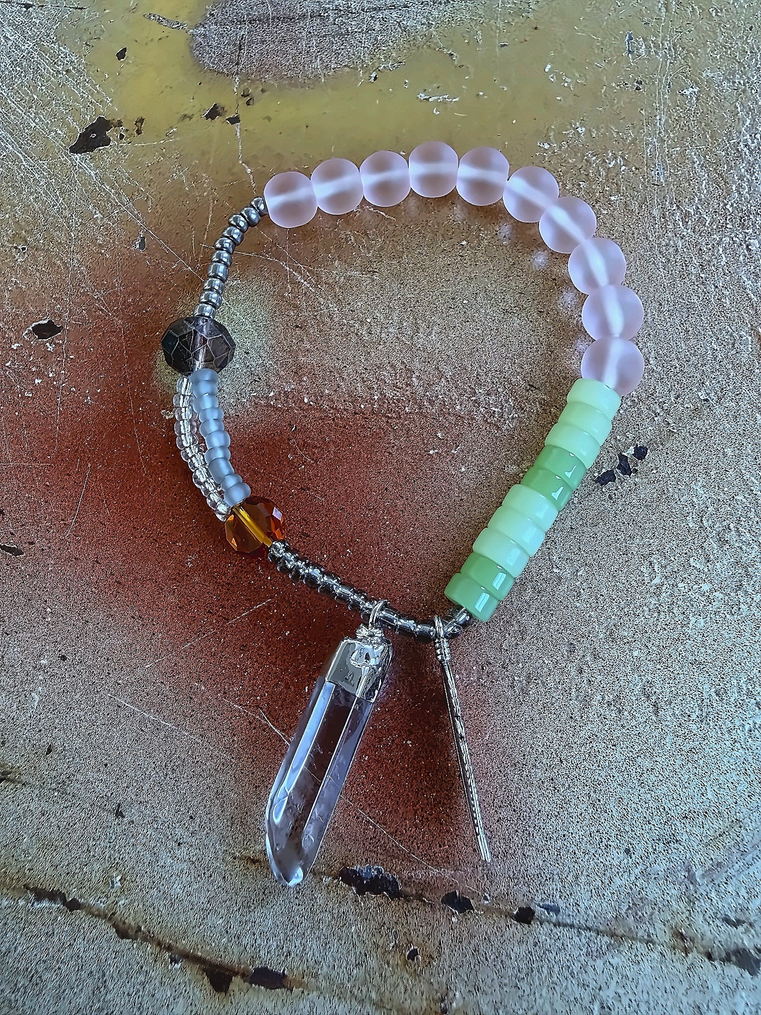 Anther House Beaded bracelet with a Natural crystal pendant on a textured surface Handmade in Philly