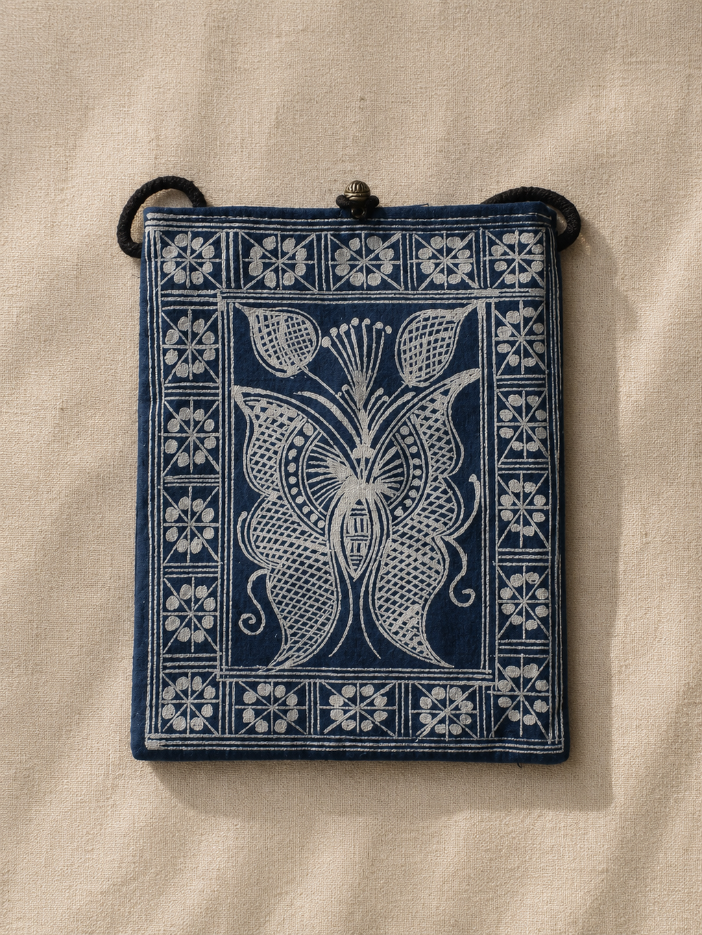 Indigo dyed artisan textile pouch featuring Chinese heritage inspired patterns, woven details, and vintage style closure