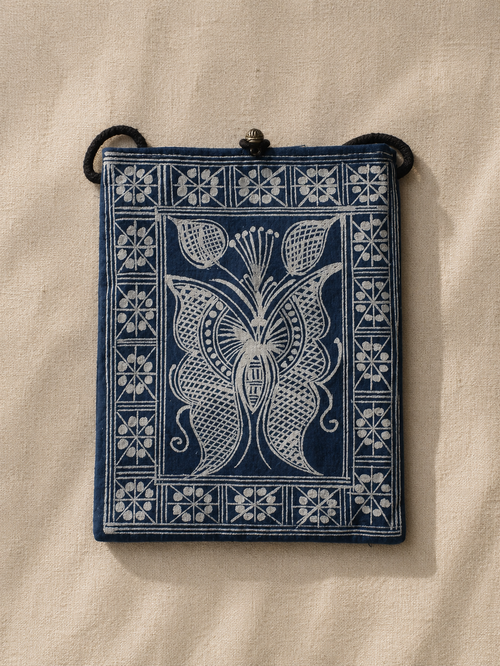Indigo dyed artisan textile pouch featuring Chinese heritage inspired patterns, woven details, and vintage style closure