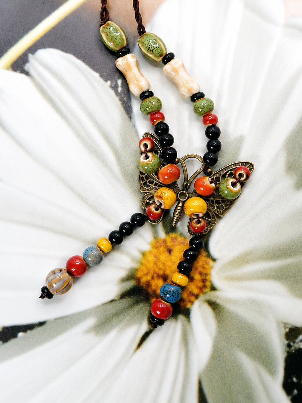 Handcrafted butterfly bead necklace with colorful mixed beads, dark cord, and vintage-inspired artisan charm centerpiece