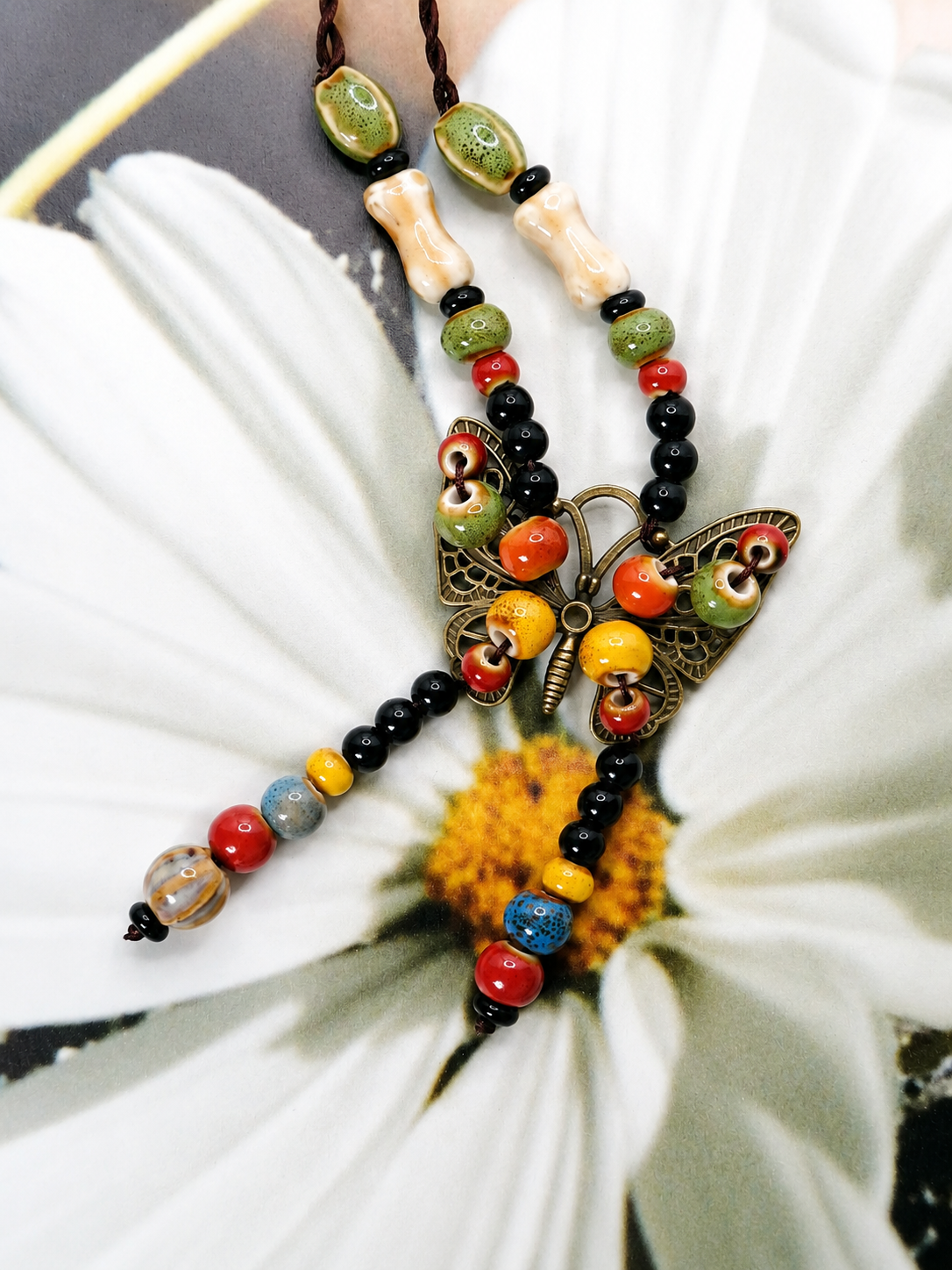 Handcrafted butterfly bead necklace with colorful mixed beads, dark cord, and vintage-inspired artisan charm centerpiece