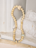 Handmade natural stone beaded bracelet with neutral cream beads, carved lotus charm, and minimalist artisan design